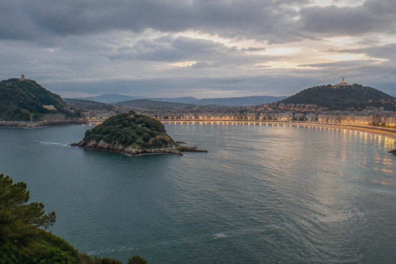 Evening view over La Concha bay in San Sebastián with the illuminated waterfront and Monte Igueldo in the distance