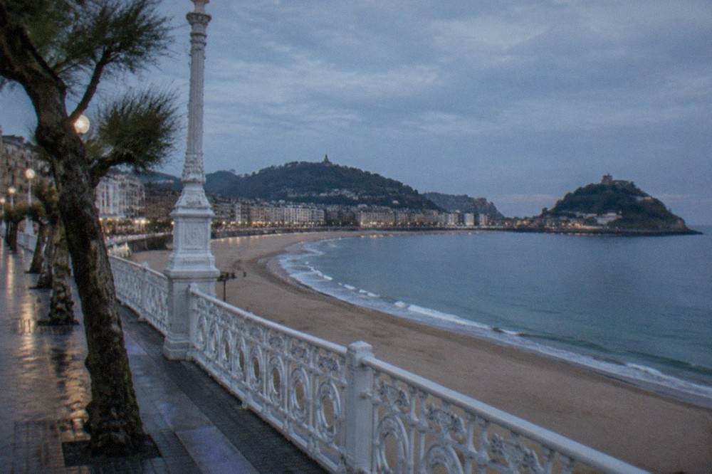 The La Concha bay promenade in San Sebastián seen from above, with the beach curving between two hills