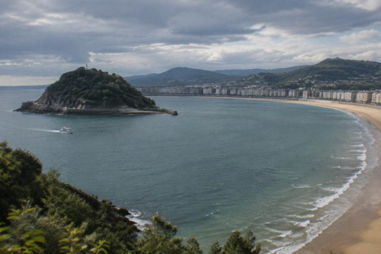 The long sandy curve of La Concha beach in San Sebastián with the bay and Santa Clara island behind it