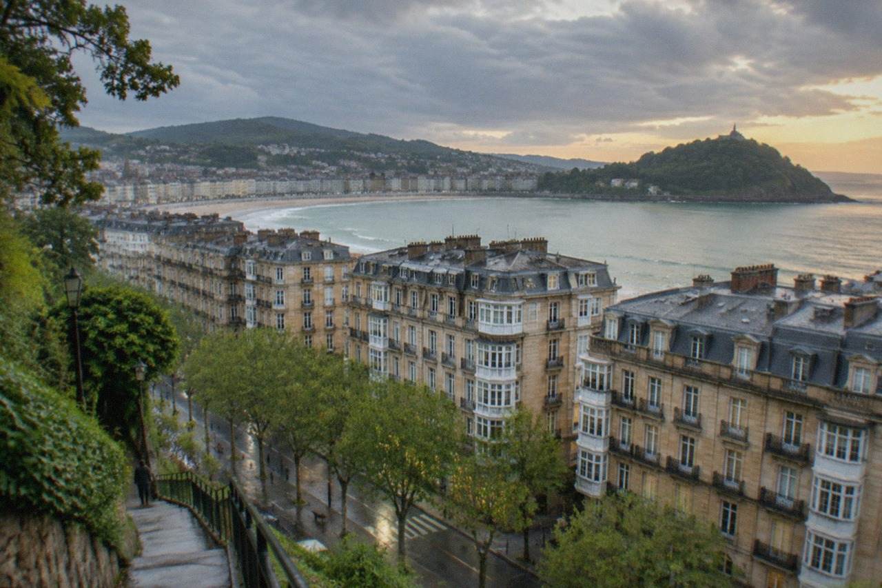 Evening light over the buildings and bay of San Sebastián from a hillside path