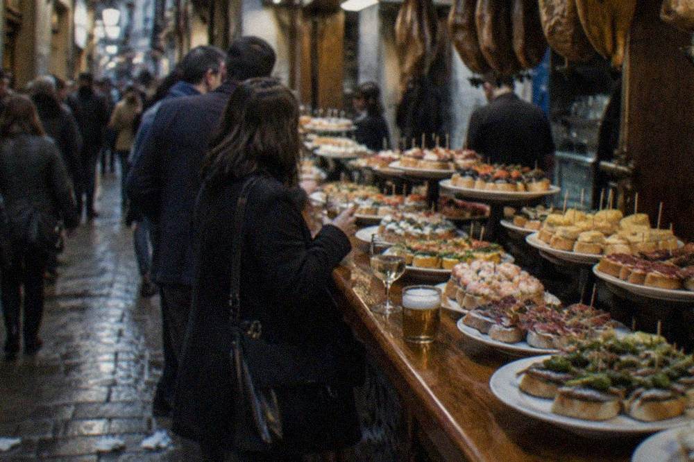 Crowds walking through the narrow pintxo bar lanes of the Parte Vieja at night