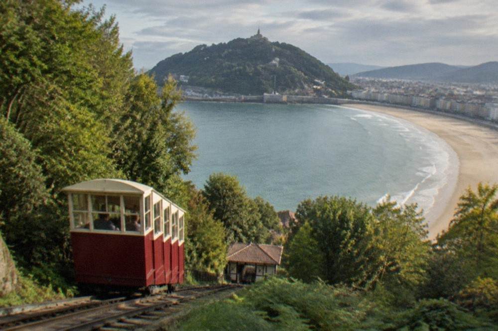 Ondarreta beach in San Sebastián with Monte Igueldo and the funicular towers rising above the sand at the far end of the bay
