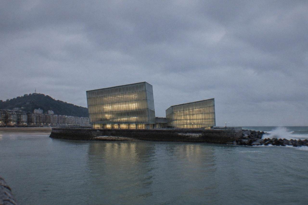 The Kursaal concert hall lit up at dusk beside the Urumea river mouth in San Sebastián
