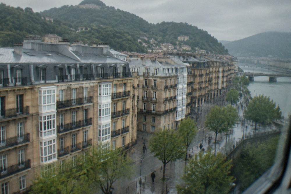Green hills and a river valley in the Basque Country seen from a train window