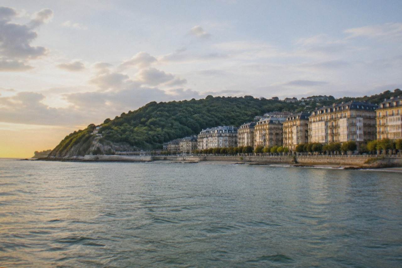 The Bay of Biscay coastline near San Sebastián seen from the water, with green hills meeting the sea