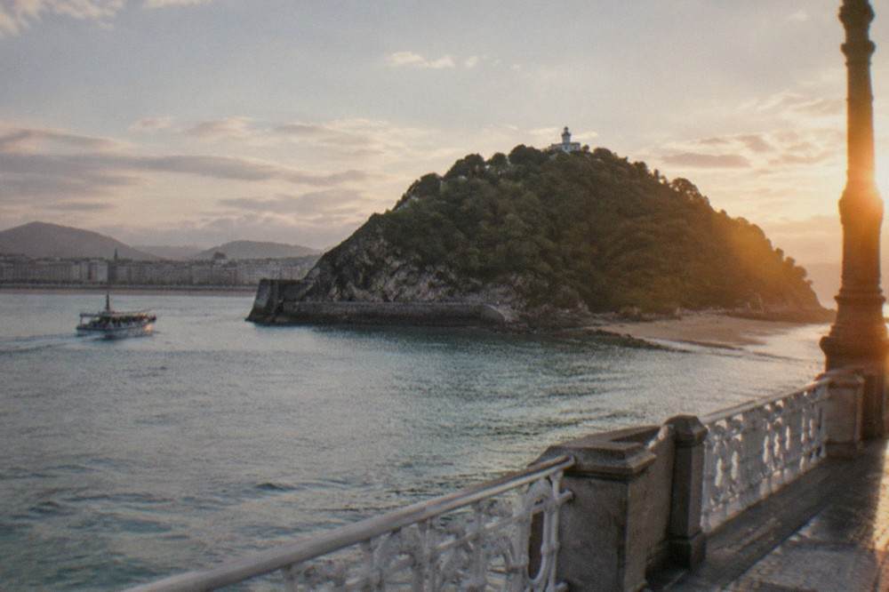 Evening light over La Concha bay with the beach promenade and Santa Clara island