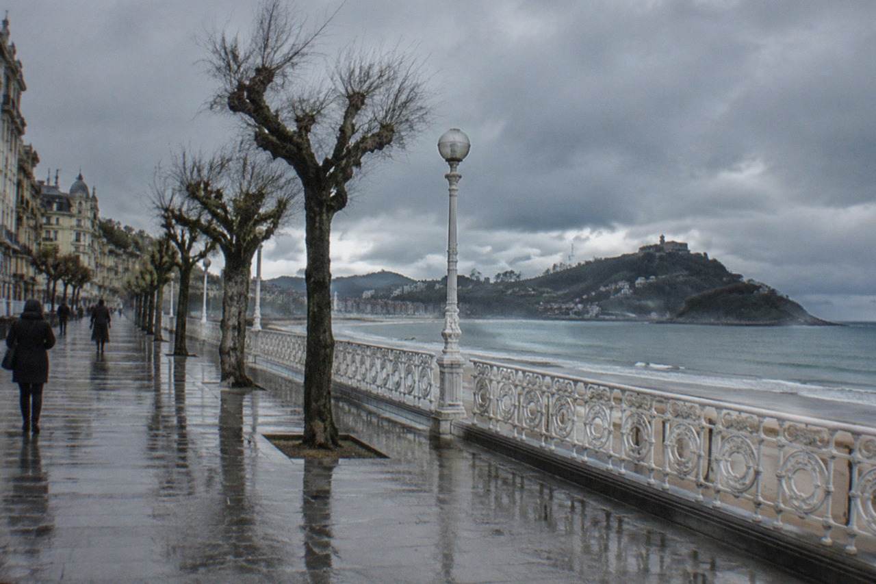 Rain clouds over La Concha bay in San Sebastián with the seafront promenade glistening wet