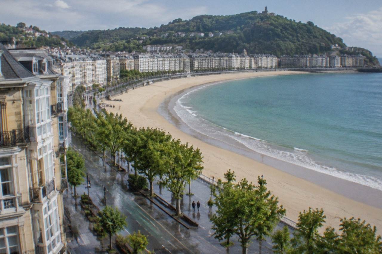 The curved sandy beach and bay of San Sebastián seen from above on a bright day