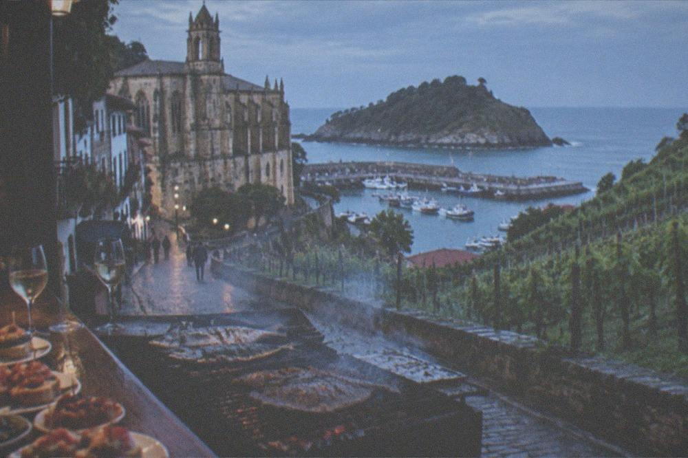 A pintxo bar counter with small skewered snacks and glasses of txakoli