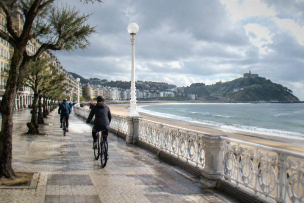 Cyclists riding along the seafront promenade beside the bay