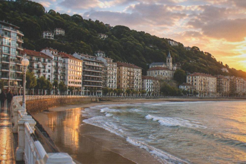 Apartment buildings of Antiguo seen from the beach promenade at golden hour