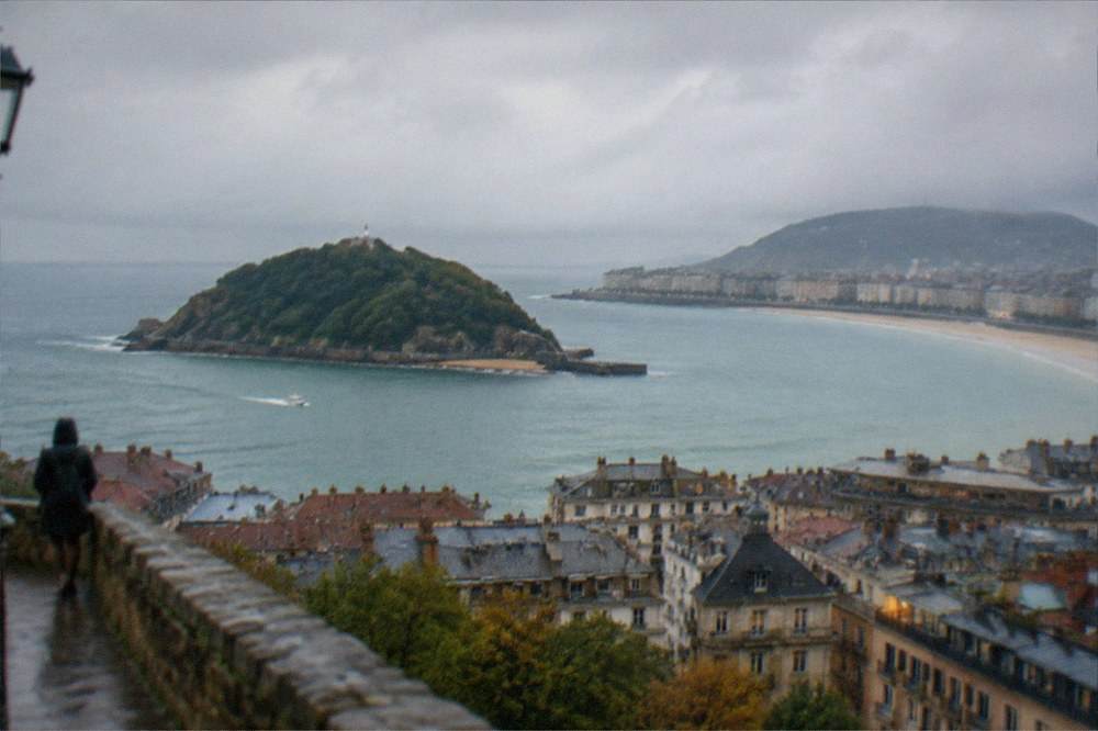 Evening light over the rooftops of San Sebastián neighbourhoods with La Concha bay and Santa Clara island beyond