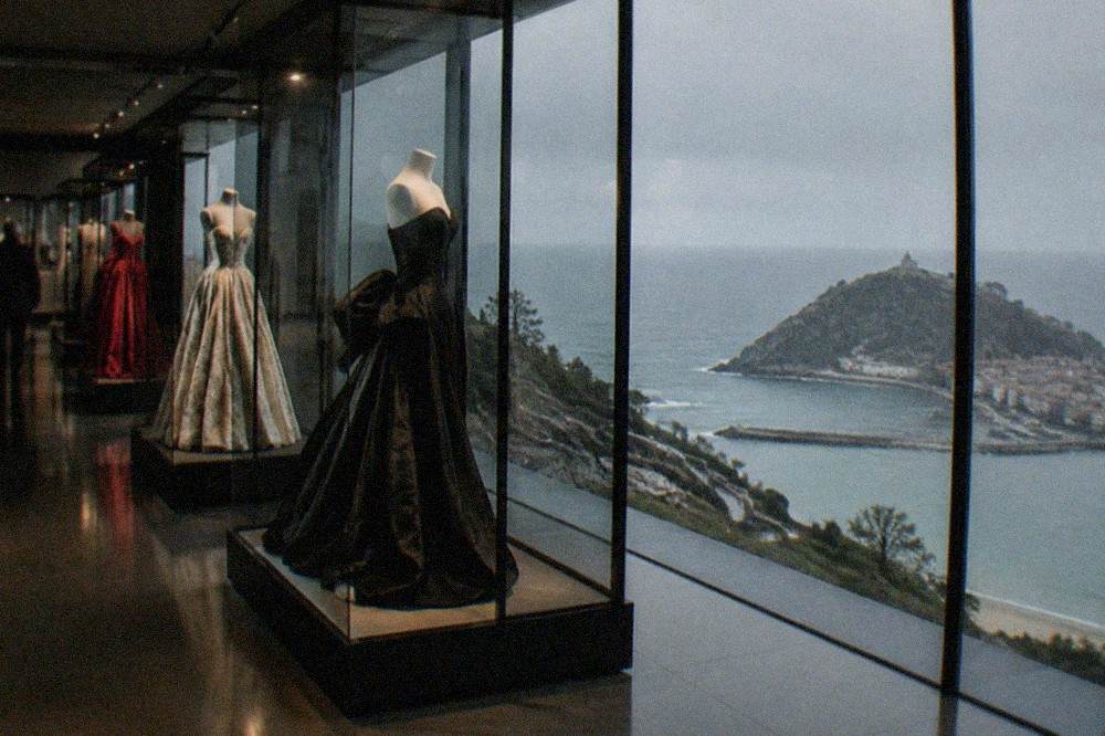 A gallery inside the Balenciaga museum with couture garments displayed in lit cases