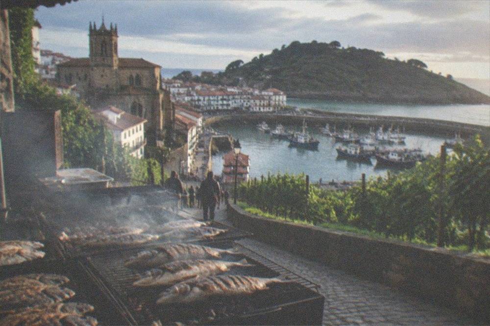 Fishing boats moored in the small harbour of Getaria with the town behind them