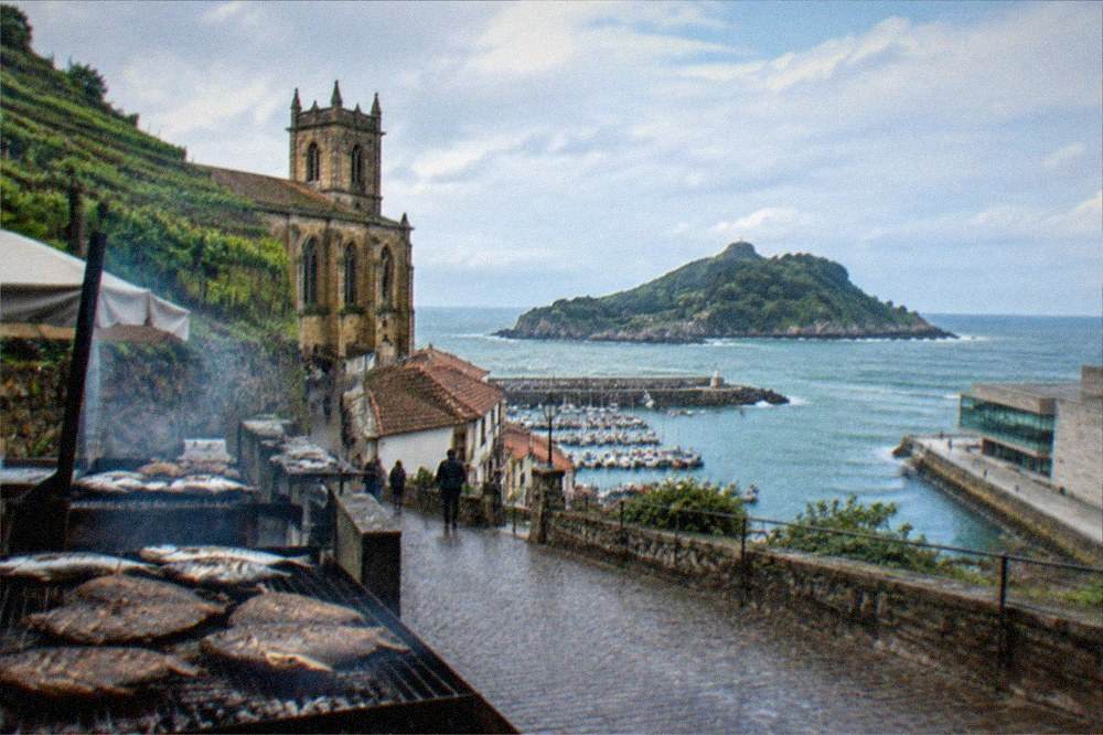 The seafront of Getaria with the museum building on the right and the headland beyond