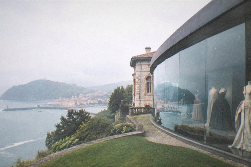 The curved glass wall of the Balenciaga museum reflecting the bay at Getaria