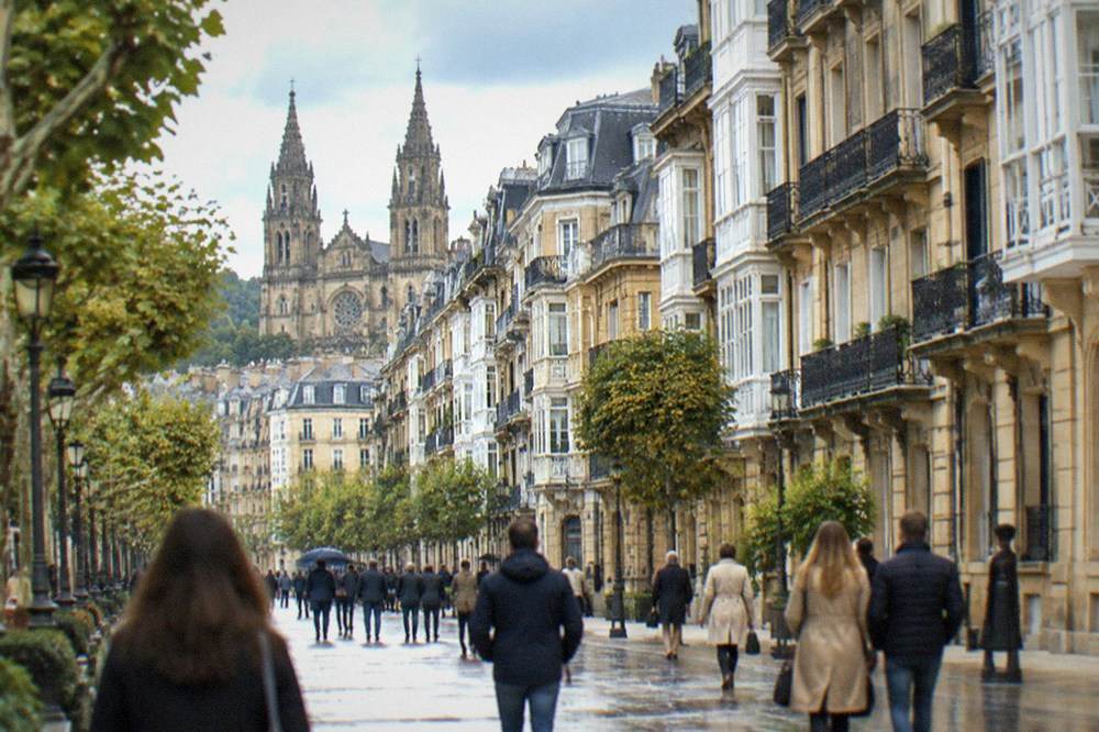 Shoppers and visitors walking the pedestrian shopping streets of Centro with the cathedral towers visible behind the rooftops.