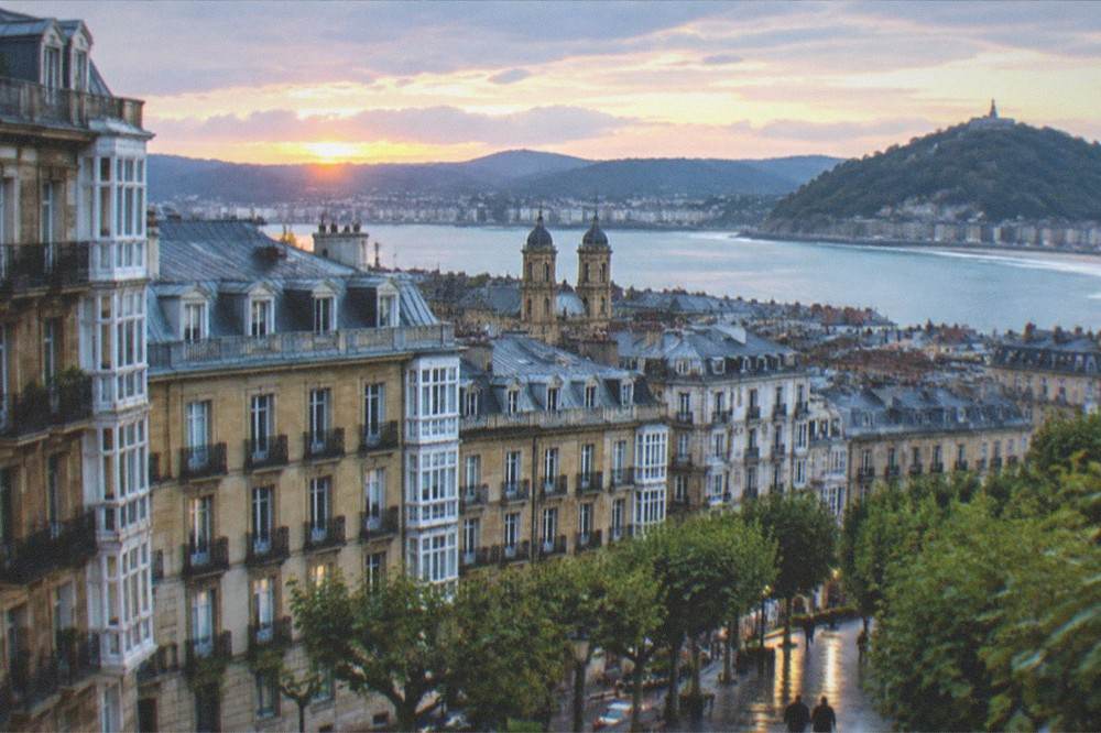 Evening light over the rooftops of San Sebastián with the cathedral towers and the bay beyond.