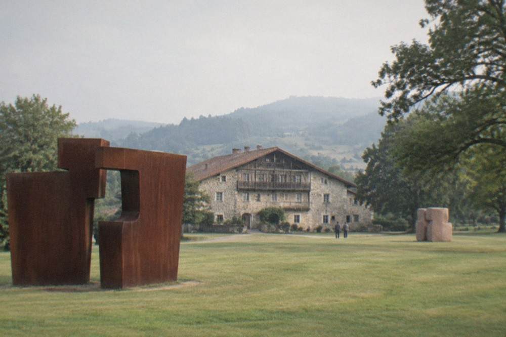 A corten steel sculpture by Eduardo Chillida on the lawn of the Zabalaga farmhouse estate