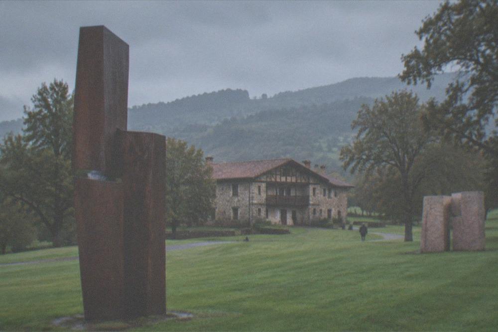 A tall steel sculpture on the lawn under a cloudy Atlantic sky at Chillida Leku