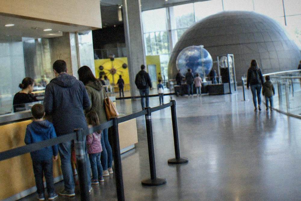 Ticket desk of a science museum with a family buying admission