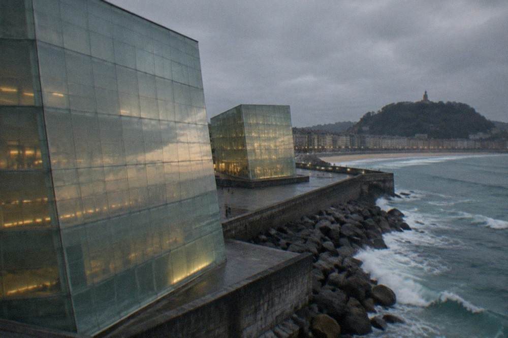 Close view of the translucent glass cladding of one Kursaal cube reflecting the evening sky