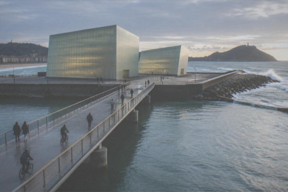 Cyclists and pedestrians crossing the bridge over the Urumea river toward the Kursaal