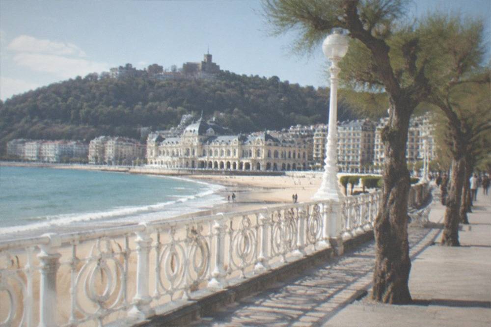 The white promenade railings of La Concha with the spa building and beach behind