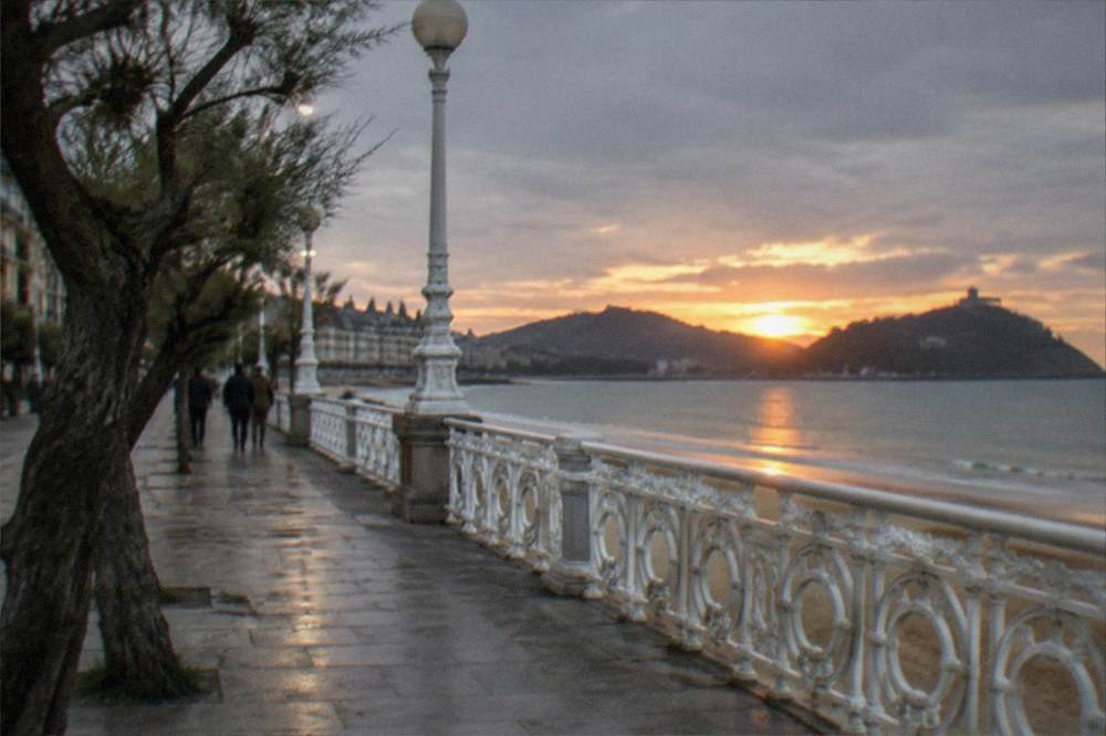 The La Concha promenade at sunset with the bay and hills in silhouette