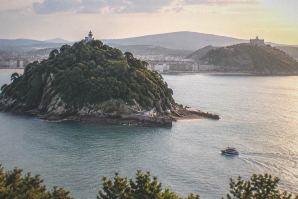Evening light over La Concha bay with the palace headland and Santa Clara island