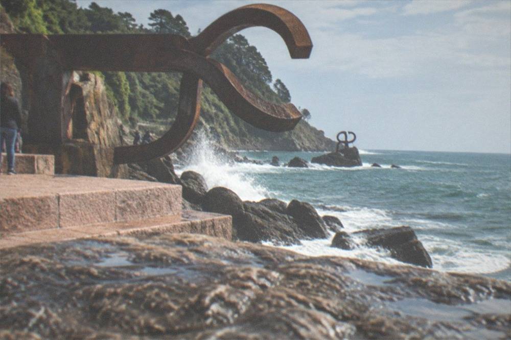 The steel sculptures of the Peine del Viento on the rocks at the foot of the hill
