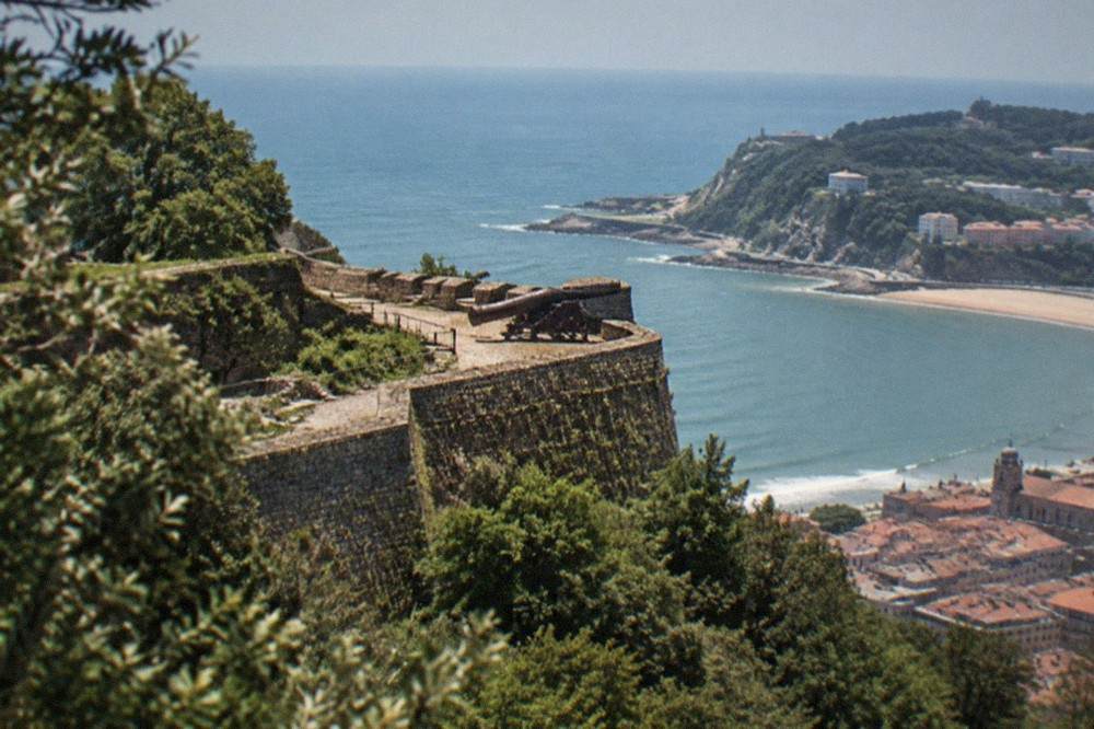 Stone walls of the Castillo de la Mota fortress seen through trees on Monte Urgull