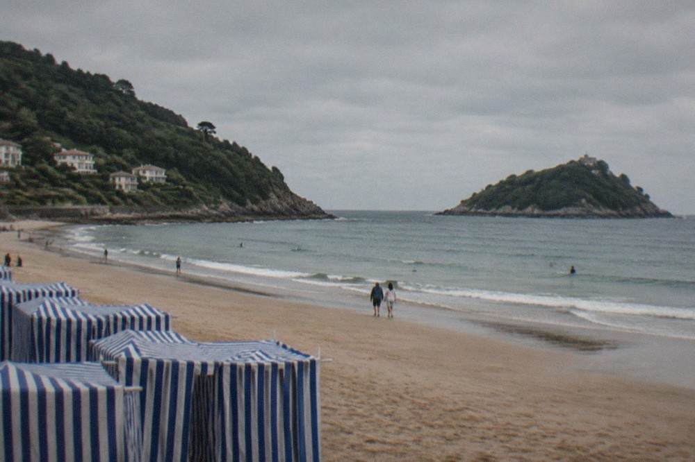 Wide view across Ondarreta Beach toward Santa Clara island in the bay