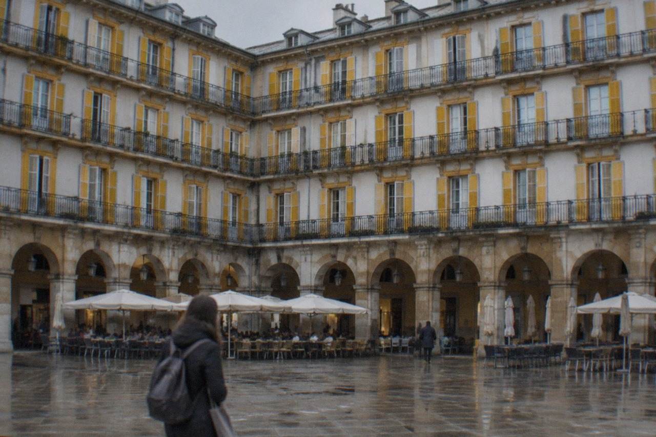 Arcaded square in the Old Town of San Sebastián with numbered balconies above and cafe tables below