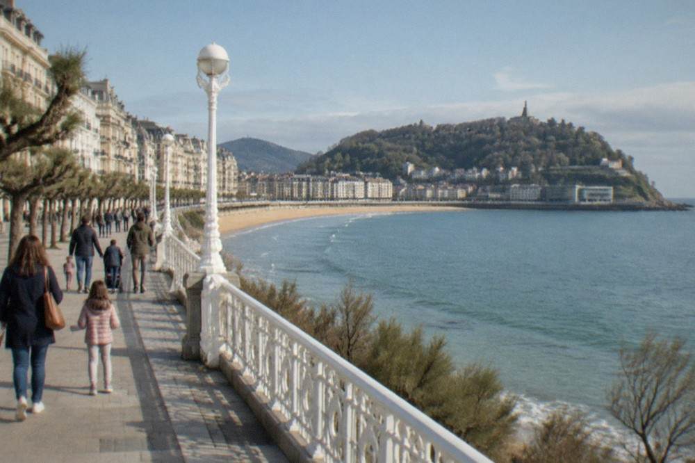 Families walking along the harbour promenade toward the aquarium entrance on a bright morning
