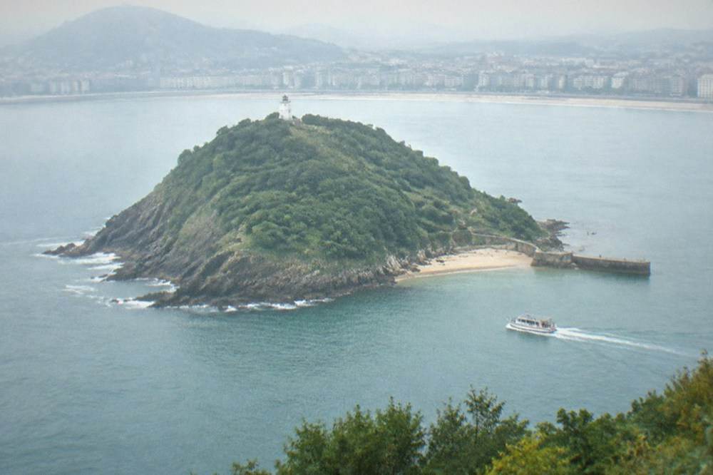 The old lighthouse on Santa Clara Island surrounded by low green scrub