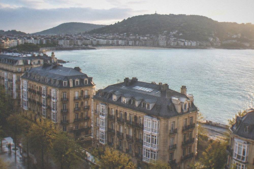 The ring of hills and rooftops of San Sebastián seen across the water from the island