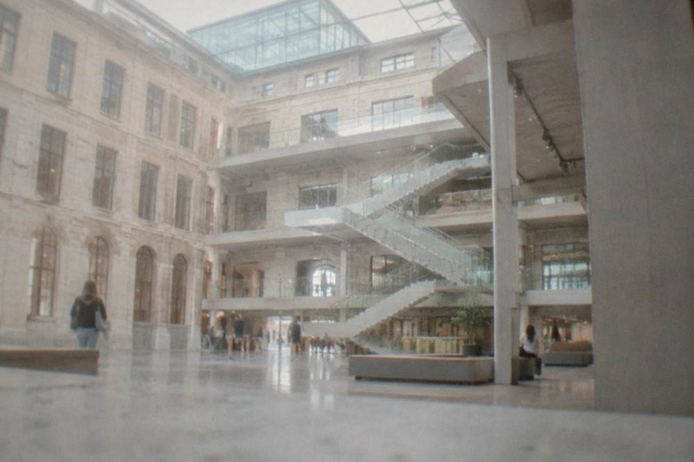 A bright interior atrium of a converted factory with modern staircases and open walkways