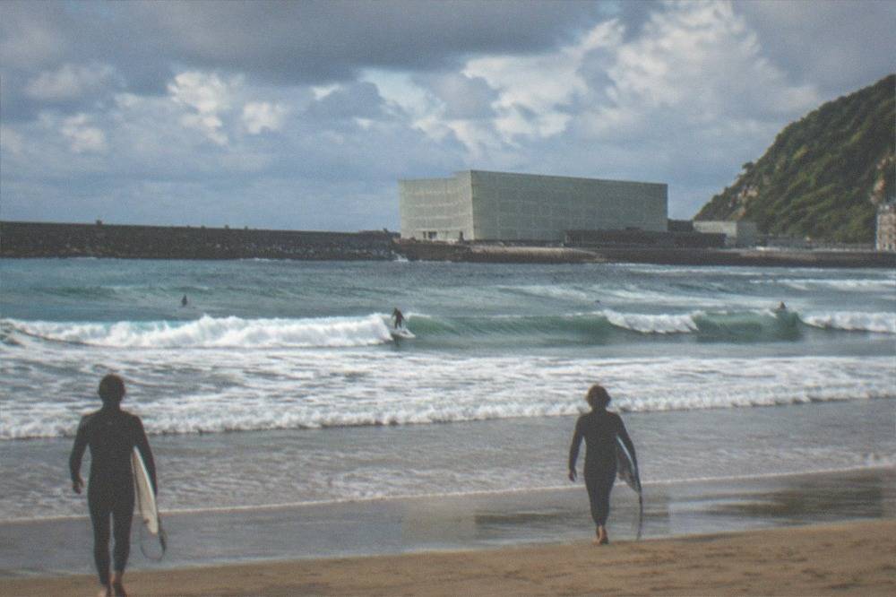 Modern concert hall building beside a river mouth near a beach