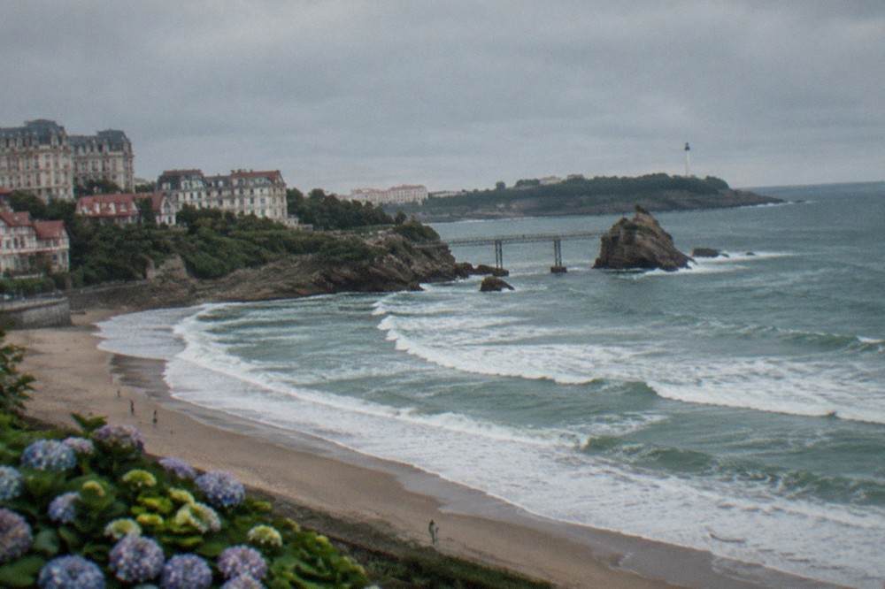 A rocky headland at Biarritz with a lighthouse and a walkway out over the Atlantic waves