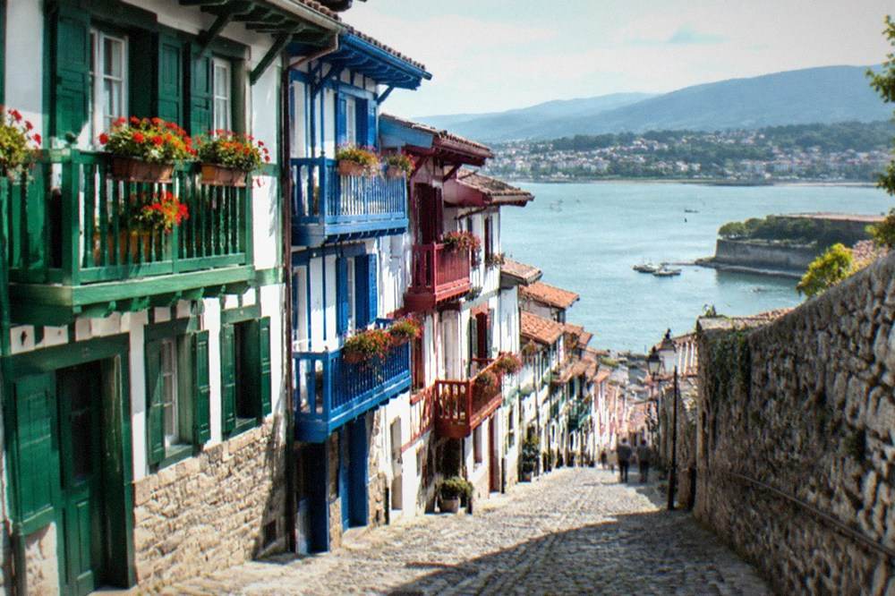 A narrow street of traditional Basque houses with painted timber facades