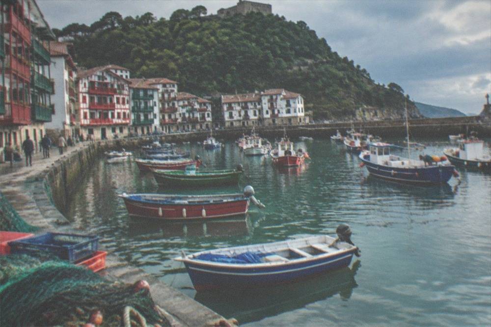 Narrow old-town streets lined with half-timbered houses painted red and green, with a river quay alongside