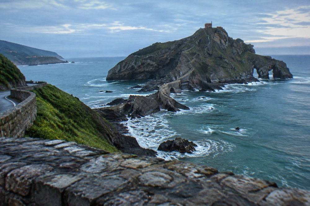 A coastal road winding along green cliffs above the Bay of Biscay in the Basque Country