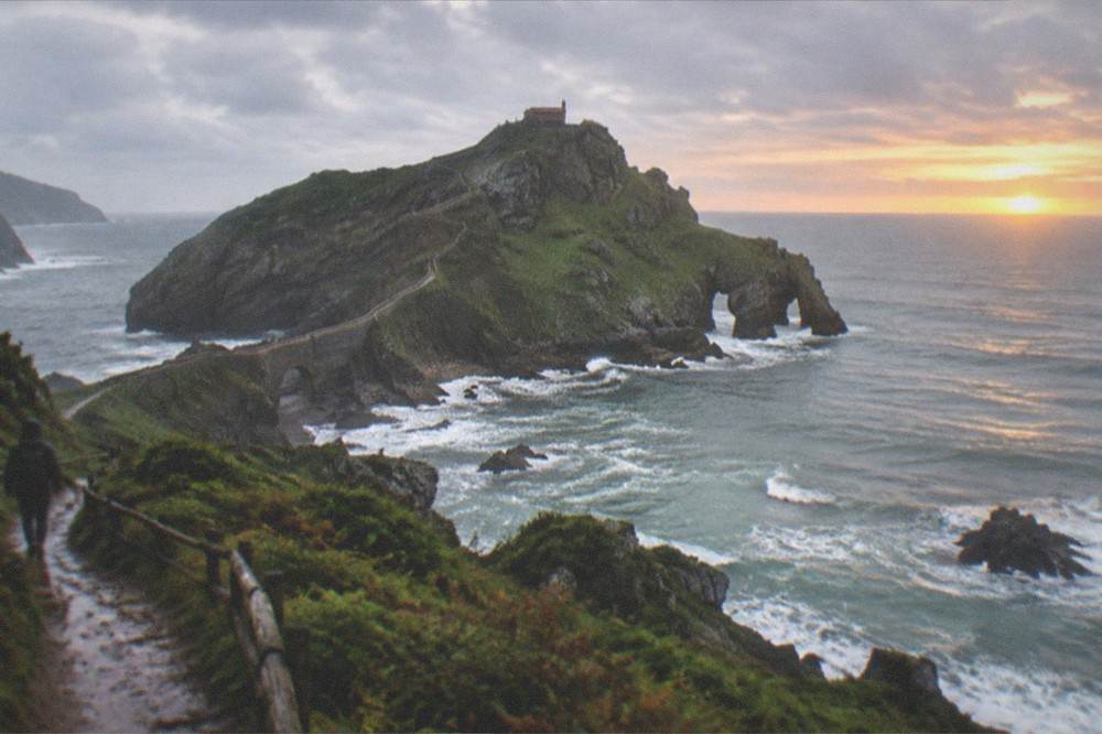 Sunset light over the Basque coastline, cliffs and sea seen from a headland path