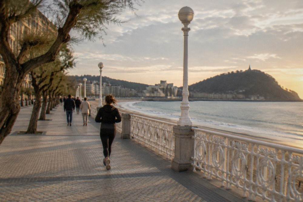 Visitors walking along the riverside promenade toward the Guggenheim Museum in Bilbao
