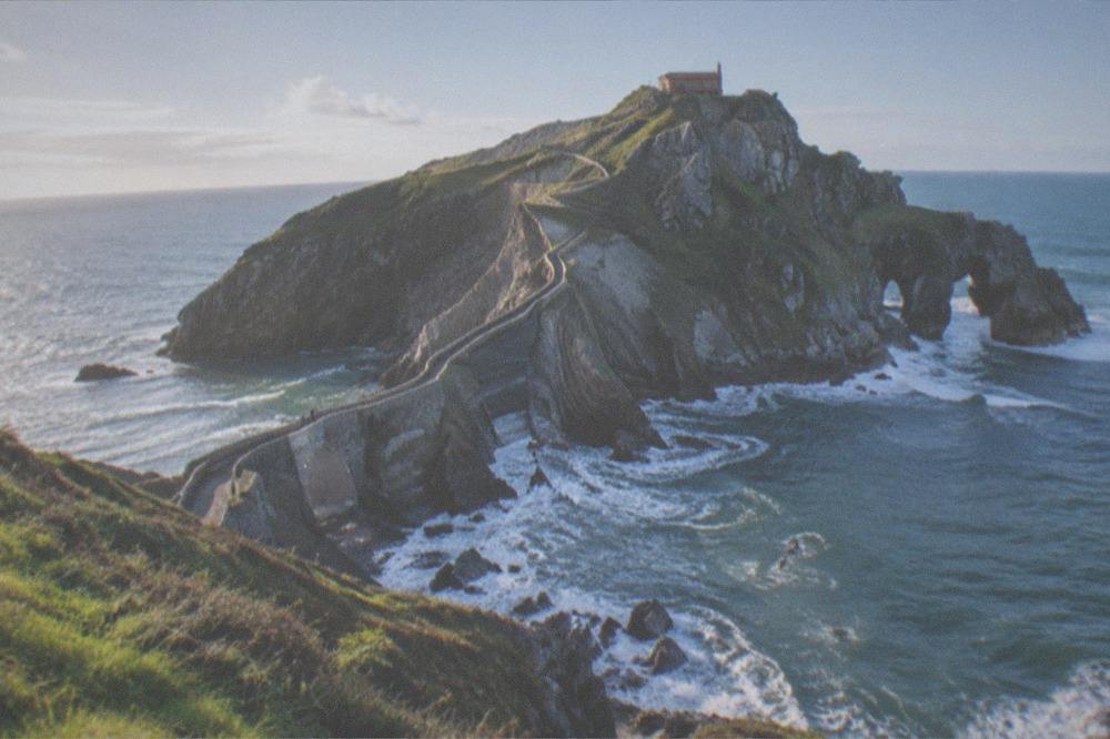 Waves breaking against the rocky coastline near the Gaztelugatxe islet on the Biscayan coast