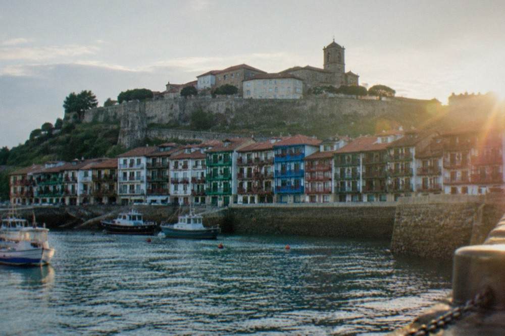 The walled old town of Hondarribia seen from below, with stone ramparts and tiled roofs