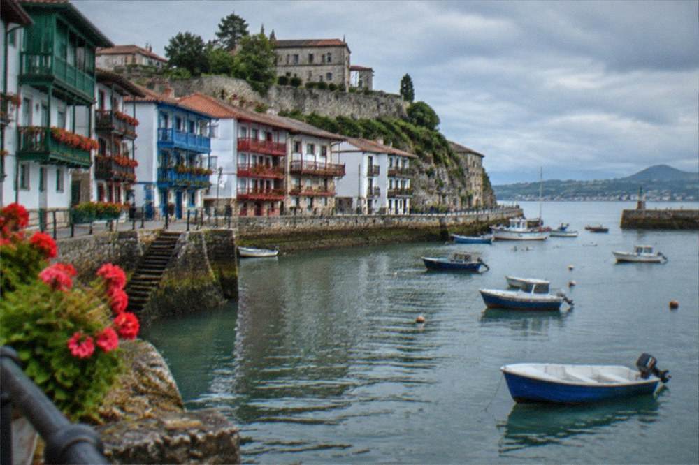 The harbour front of Hondarribia under an Atlantic sky with clouds over the bay