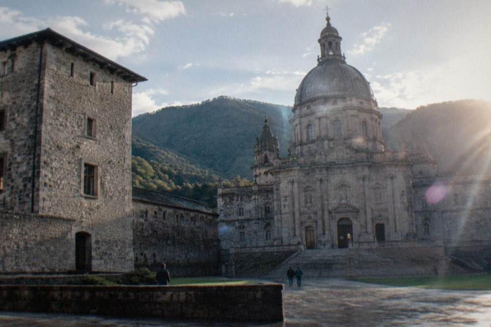 A stone tower house of the Loyola family residence with thick defensive walls, seen from the courtyard of the sanctuary