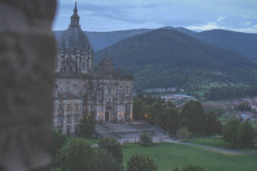 A view over green Basque countryside with wooded hills and a small valley settlement in Gipuzkoa